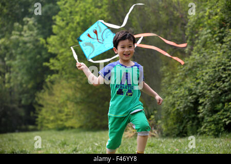 Boy playing kite in field Stock Photo