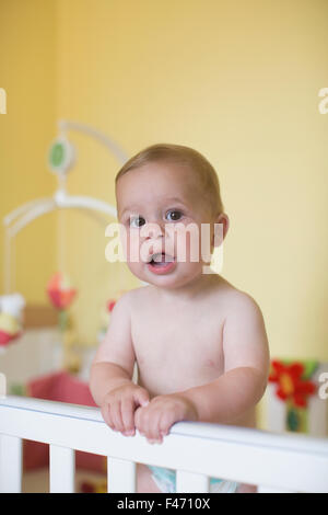 11 month old Caucasian boy, stands in his cot, London, England, United Kingdom Stock Photo