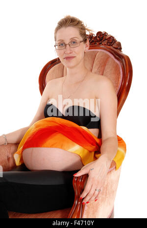 Pregnant woman in armchair. Stock Photo