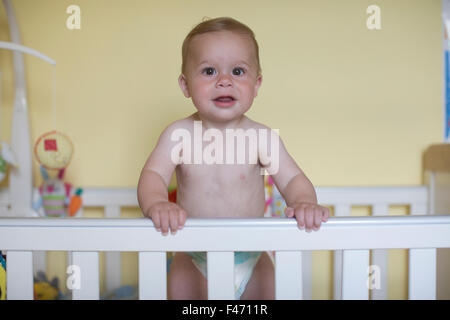 11 month old Caucasian boy, stands in his cot, London, England, United Kingdom Stock Photo