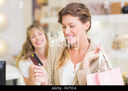 Beautiful customer at cash register holding credit card Stock Photo