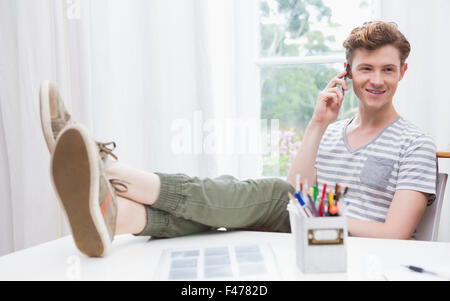 Young man relaxing in a chair and having a phone call Stock Photo