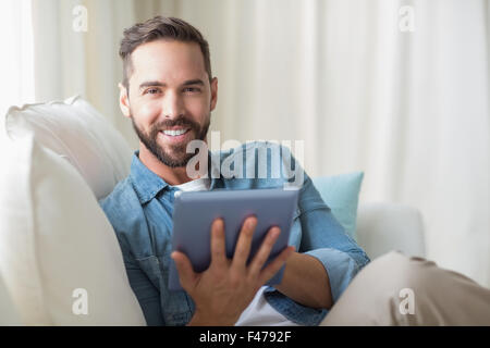 Smiling man using a digital tablet Stock Photo