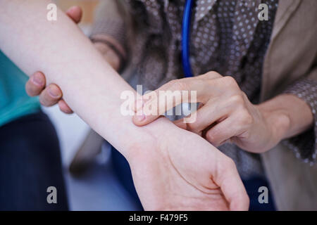 TAKING A WOMAN'S PULSE Stock Photo