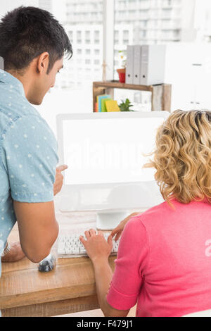 Colleagues using computer together Stock Photo