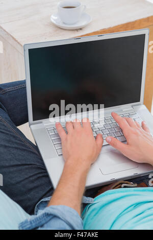 Man using laptop computer in living room Stock Photo