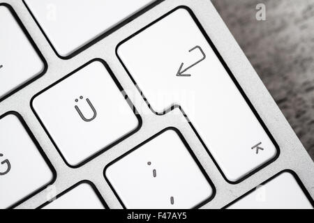 Close up of a white, gray computer keyboard. Focus on enter key Stock Photo
