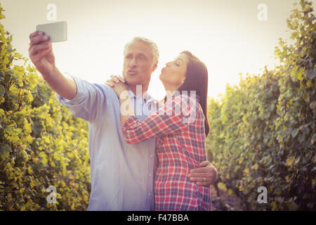 Happy couple blowing kiss and taking selfies Stock Photo