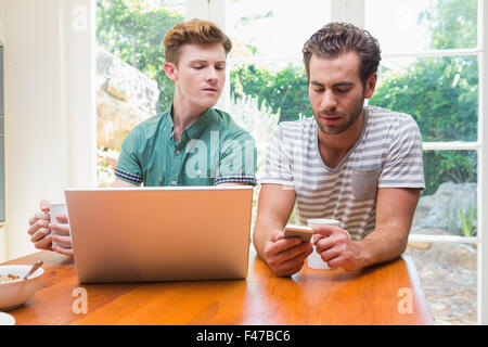 Homosexual couple using multimedia technologies Stock Photo