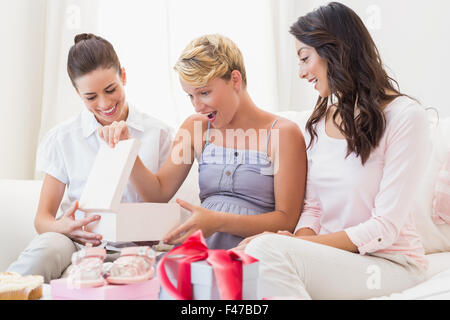Pregnant woman opening a baby gift Stock Photo