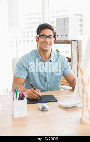 Portrait of smiling casual businessman working with digitizer and looking at camera Stock Photo