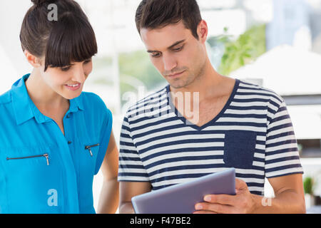 Casual business team looking at tablet together Stock Photo