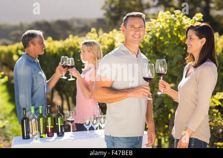 Portrait of couple drinking in front of other couple talking and drinking Stock Photo