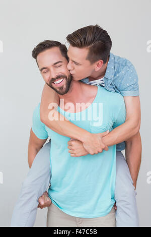 Happy homosexual couple kissing and having piggy back Stock Photo