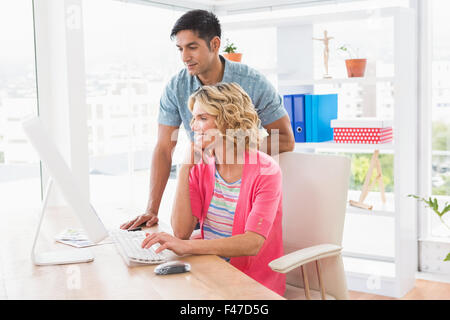 Smiling colleagues working together with computer Stock Photo