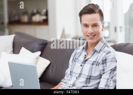 Smiling handsome man using a laptop Stock Photo