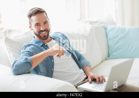 Smiling man working on laptop on the sofa Stock Photo