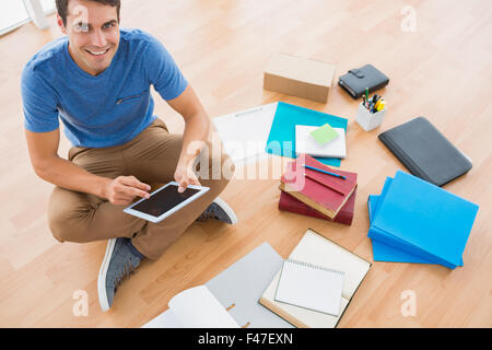 Young businessman working on the floor with tablet Stock Photo