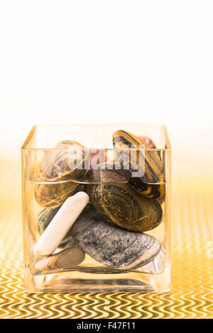 glass beaker filled with water and stones Stock Photo
