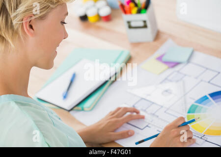 Smiling creative businesswoman drawing plans Stock Photo