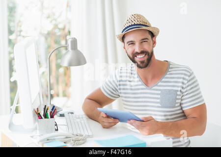 Happy handsome man looking at camera and holding tablet computer Stock Photo