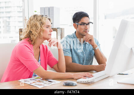 Concentrated colleagues using computer together Stock Photo