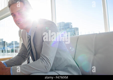Happy business man sitting on sofa and looking at camera Stock Photo