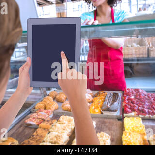 Composite image of woman using tablet pc Stock Photo