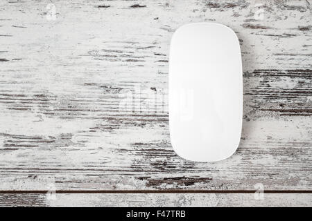Wireless white modern computer mouse on white wooden background with copy space Stock Photo