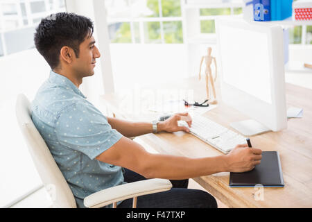 Smiling casual businessman using computer and digitizer Stock Photo