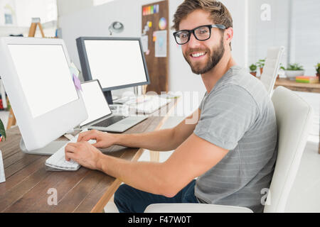Handsome businessman sitting on a swivel chair and using his laptop Stock Photo