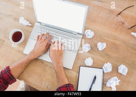 Man typing on laptop at desk Stock Photo