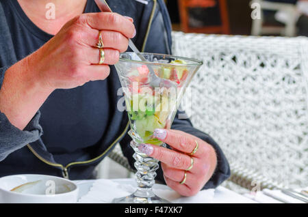 Woman enjoying an exotic fruit salad Stock Photo