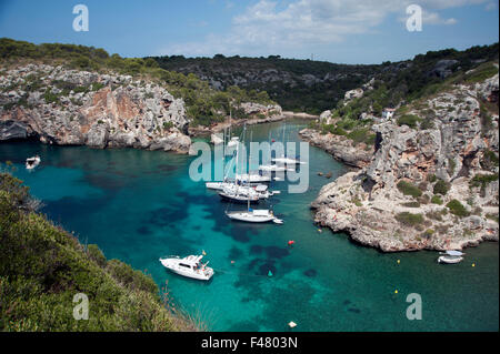 Sailing yachts moored in the secluded rocky cove of Calas Coves on the island of Menorca Spain Stock Photo
