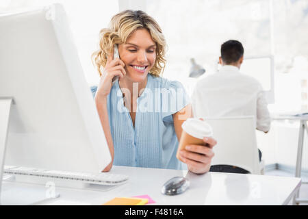 Young smiling businesswoman in the office holding a mobile Stock Photo