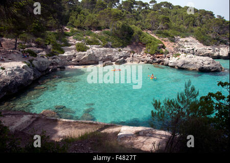 The clear azure waters of cala Mitjana from the cliffs above on the island of Menorca Spain Stock Photo