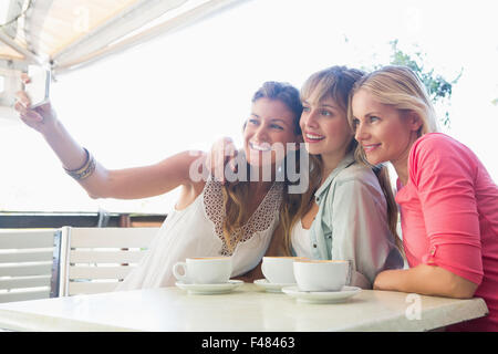 Happy friends having coffee together taking selfie Stock Photo