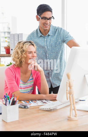Smiling colleagues working on computer Stock Photo