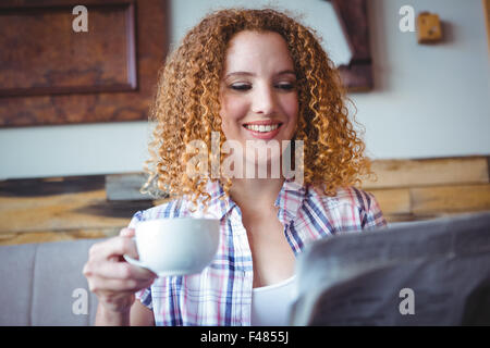 Happy smiling woman reading newspaper and drinking coffee Stock Photo