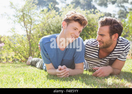 Happy homosexual couple lying on grass Stock Photo