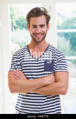 Handsome man smiling at camera with arms crossed Stock Photo