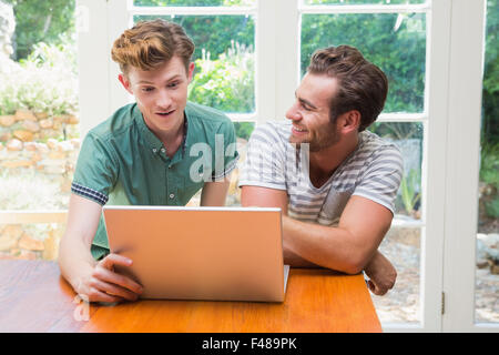 Homosexual couple looking at laptop computer Stock Photo