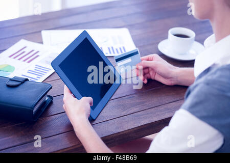Businesswoman using tablet pc and holding credit card Stock Photo