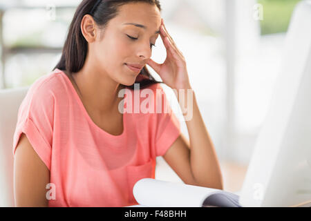 Pretty creative businesswoman reading file Stock Photo