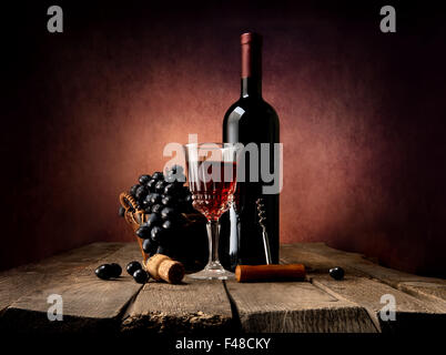 Grape in basket with wine on a wooden table Stock Photo