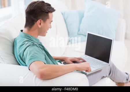 Smiling handsome man using a laptop Stock Photo
