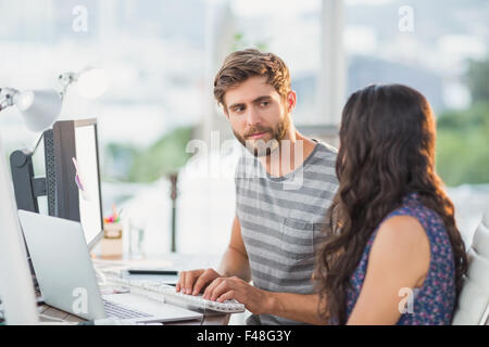 Casual business partners looking at laptop Stock Photo