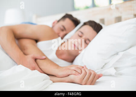 Homosexual couple sleeping on bed Stock Photo