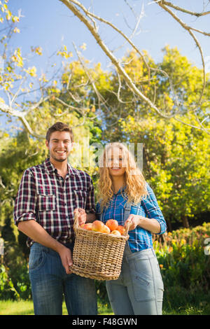 Couple holding basket of apples Stock Photo