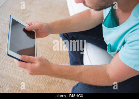 High angle view of man sitting on couch using tablet Stock Photo